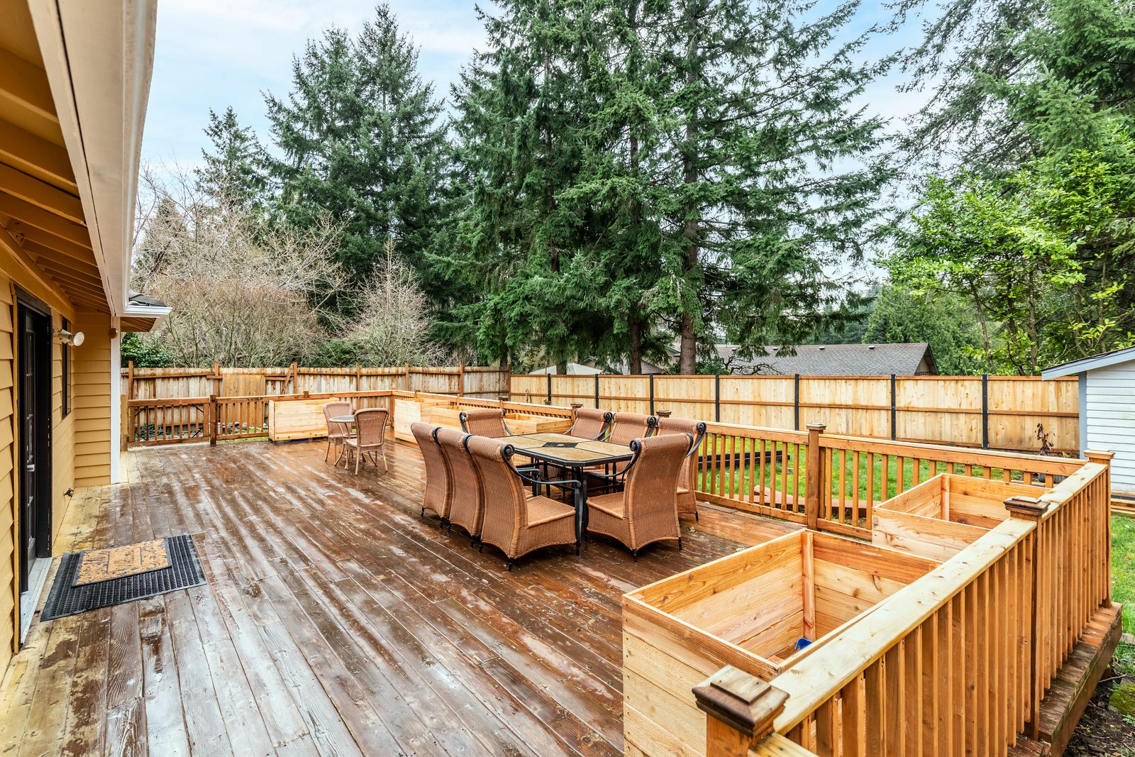 The covered deck with cedar raised garden beds, where residents plant and water.