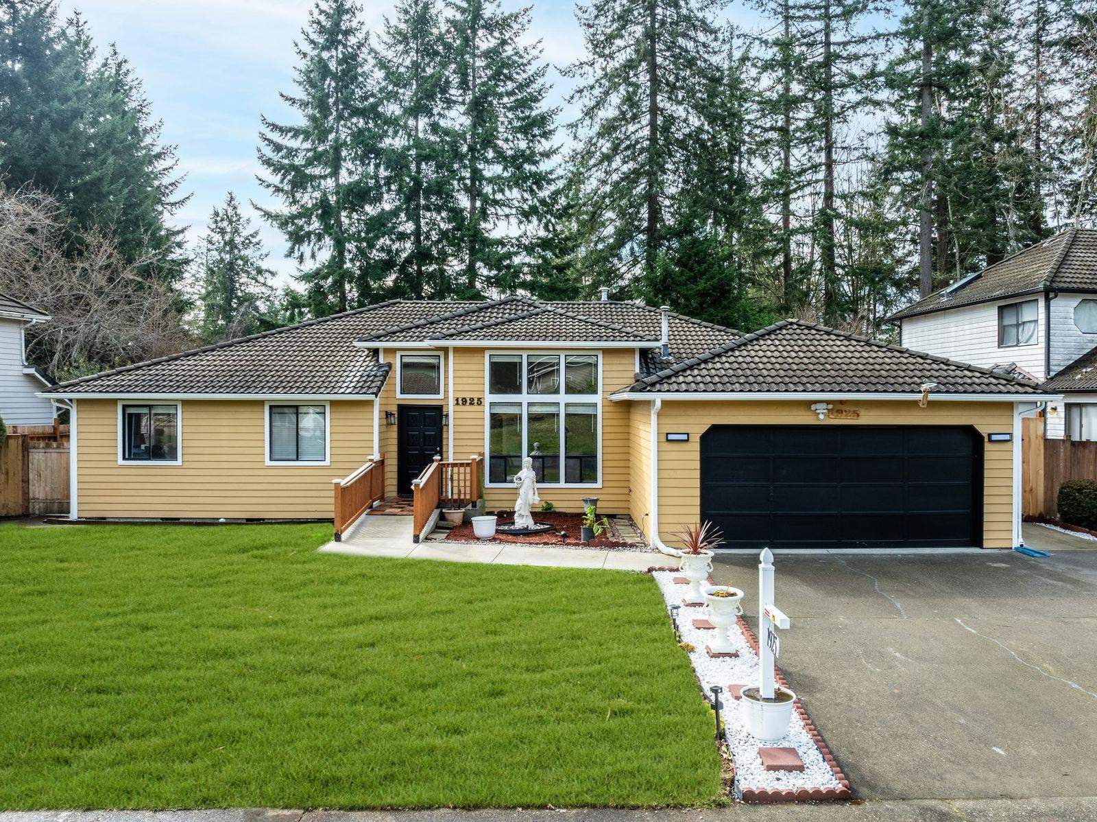 The front of the home from the street, with a wide lawn and a two-car driveway.
