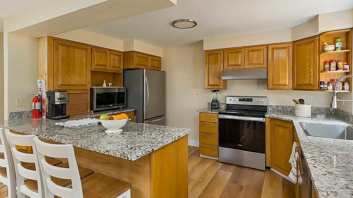 The kitchen at Olympia Senior Care, with granite counters, a breakfast bar and a stainless range.