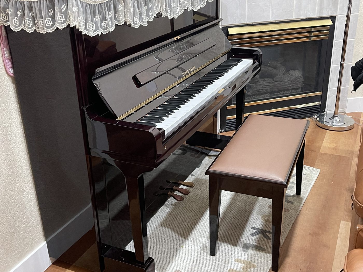 The upright piano beside the living room fireplace at Olympia Senior Care.
